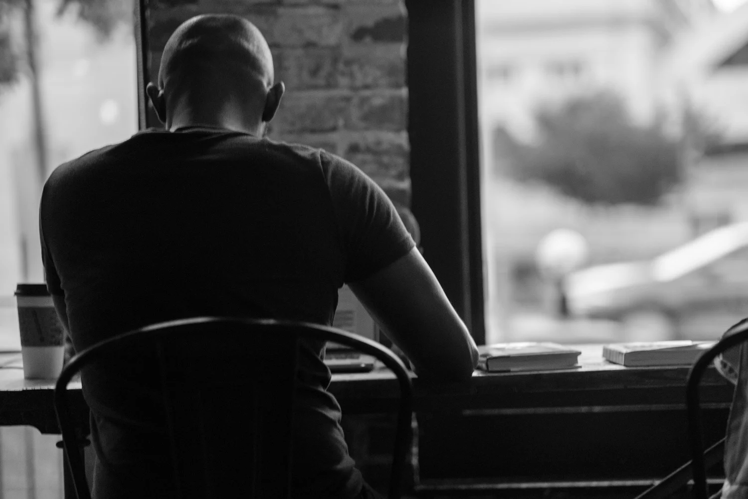 Street photograph — man at a cafe window